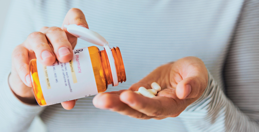 Sick woman taking pills from bottle