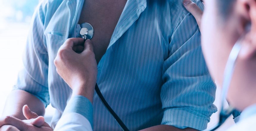 Asian doctor is using a stethoscope listen to the heartbeat of the elderly patient.