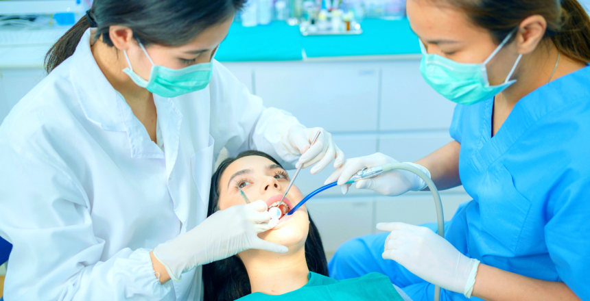 dentist wearing face mask use medical instruments for oral care at dental clinic